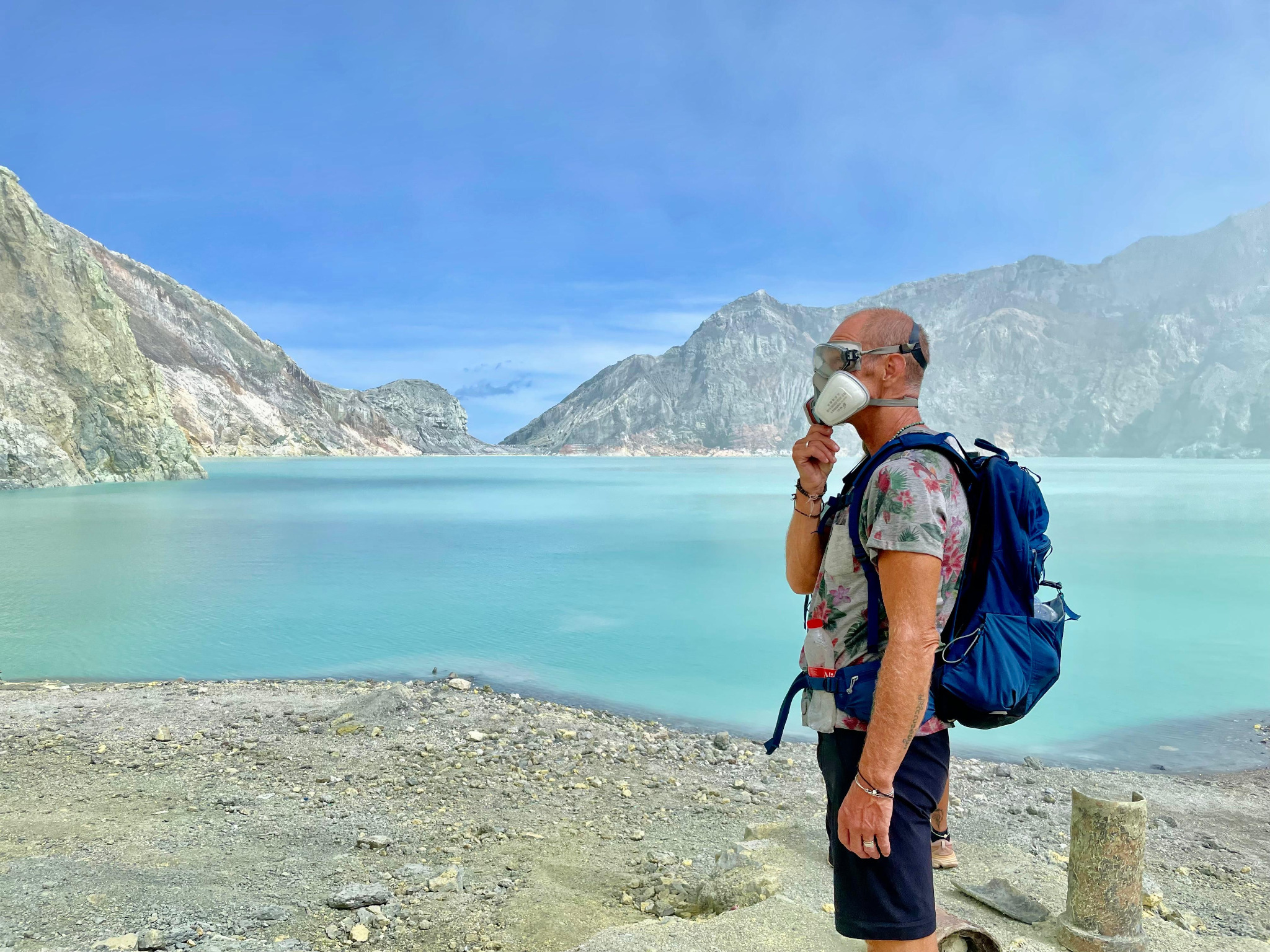 Traveller overlooking the turquoise Ijen crater lake